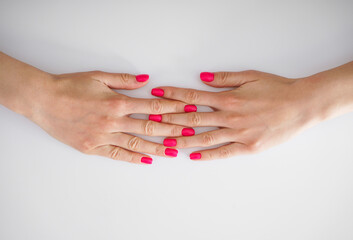 Beautiful hands of a young woman and beautiful manicure on a white background, flat-lay. Beauty and skin care concept.