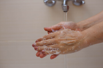 Person washing hands with antibacterial solution.