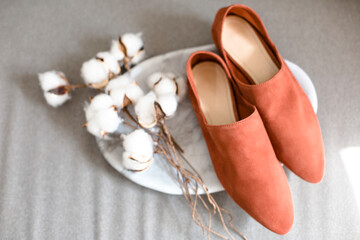 comfortable casual suede shoes for business meetings lie on a beautiful background, brown color of straw and wheat and cotton flowers decorate the trendy and modern background