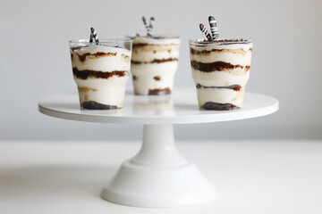 Classic tiramisu in a glass and light background. portioned tiramisu on light background.