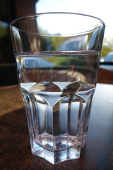 A glass of water on wooden table in nature