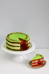 Raspberry cake with pistachio on a light background. red velvet cake. sliced dessert closeup