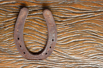 old and rusty horseshoe on rustic wooden table