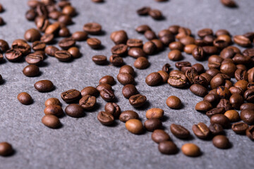 Roasted coffee beans on a stone background. Coffee beans texture. Coffee in beans on dark background. Food background of coffee beans. Abstract background texture. Texture coffee.