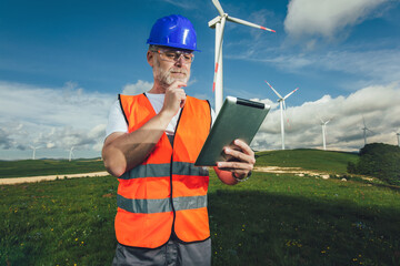 Windmill engineer inspection and progress check wind turbine, using digital tablet.