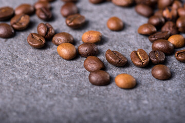 Roasted coffee beans on a stone background. Coffee beans texture. Coffee in beans on dark background. Food background of coffee beans. Abstract background texture. Texture coffee.