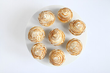 Lemon curd tarts with meringue on white background Chamomiles whole and slices of fresh lemon on a white stone background. Copy Space. Flat lay. Top View.