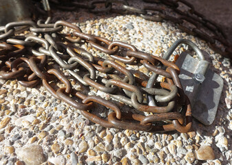 Old rusty iron chain on white stones