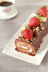 Chocolate cake roll with strawberries, nuts and cheese cream