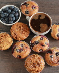 Blueberry muffins on a rustic wooden table and a cup of coffee