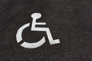 disabled parking sign on grey city asphalt