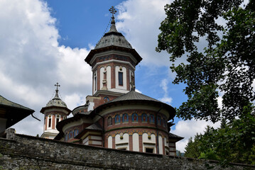 Fototapeta na wymiar Stone religious building of Christian Orthodox church built in the Byzantine style. Old Orthodox Monastery with a beautiful architecture. Romania, Sinaia.