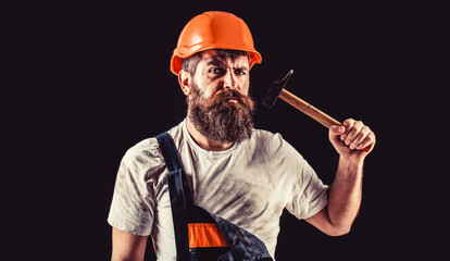 Bearded builder isolated on black background. Hammer hammering. Builder in helmet, hammer,...