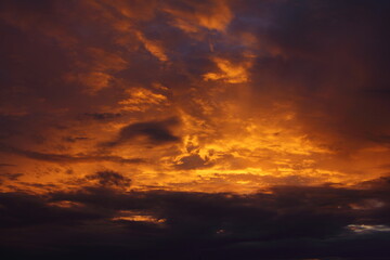 Obraz premium Ciemnoniebieski pomarańczowy wietrzny dramatyczny zachód słońca niebo z promieniami słońca oświetlone burzowymi chmurami w letni wieczór, piękny krajobraz chmur, tekstura tła i tapety