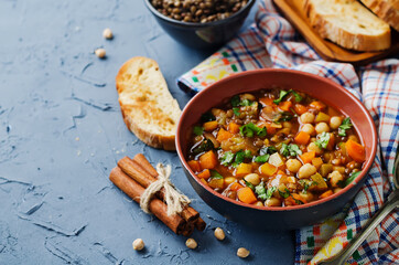 Moroccan spicy green lentils chickpea soup in a dark bowl