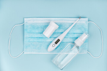 Medical mask, pills and thermometer on blue background. Coronavirus concept. 2019 nCoV.