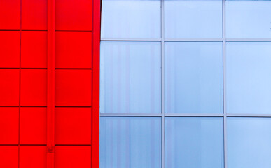 Part of the facade of a red building with windows. Glass modern building concept