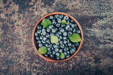 Blueberries in wood dishes on dark background. Healthy eating and nutrition.