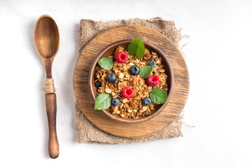 Healthy breakfast with granola and berries on white background.
