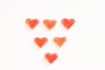 Red marmalade hearts in sugar on a white background. Marmalade sweets. Valentine's Day. Dessert. Copy space. View from above