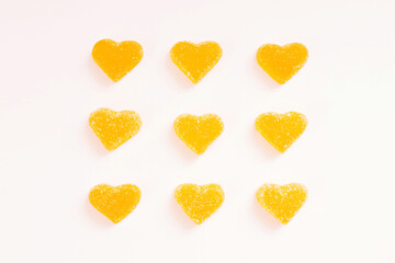 Yellow marmalade hearts in sugar on a white background. Marmalade sweets. Valentine's Day. Dessert. Copy space. View from above