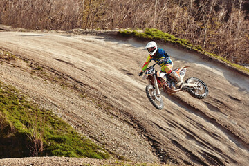 Motocross concept, a biker goes off-road making extreme skiing. In pursuit of adrinalin, sport concept. Dangerous sport.