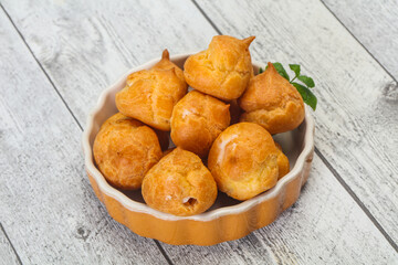 Sweet tasty profiteroles heap in the bowl
