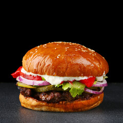 tasty burger with beef on dark isolated background. Homemade hamburger or burger with fresh vegetables and cheese