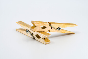 Two traditional wooden clothes pegs isolated on a plain white background