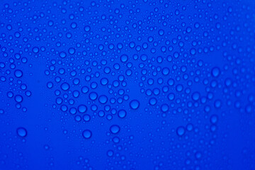 Naklejka na ściany i meble drops of pod on frosted glass on a blue background