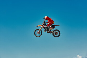 Motocross concept, a biker goes off-road making extreme skiing. In pursuit of adrinalin, sport concept. Dangerous sport.