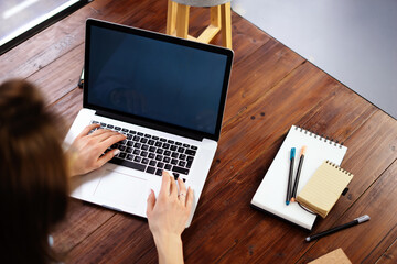 Fototapeta premium Mockup image of a woman using laptop with blank screen on wooden table