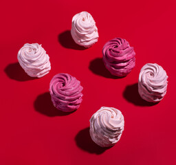 set of colorful meringue on red background