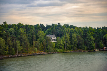 Fototapeta na wymiar House among the trees in Finland small islands near Turcu
