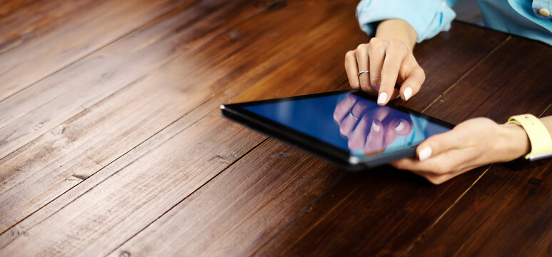 Woman pointing on digital tablet screen, chatting in social networks, meeting website, searching internet, sending sms, using text messenger or online banking. Close up photo