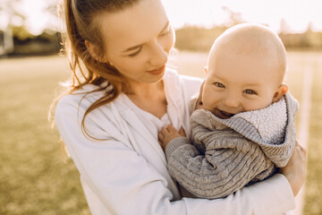 Beautiful young woman mom with baby outdoors