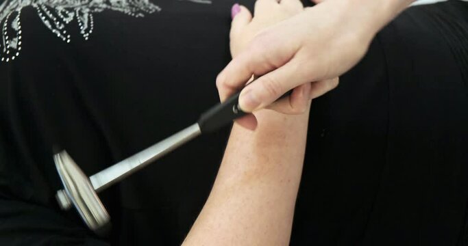 Doctor the neurologist examines the patient taps with a hammer on the knee