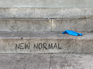 A stone staircase on which a disposable glove has been thrown. On the step there is a text that...