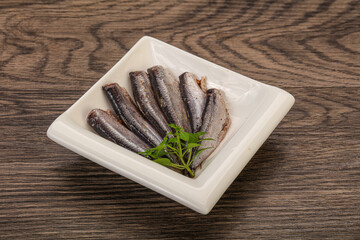Anchovies in the bowl served basil leaves