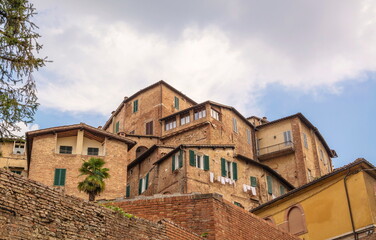 Fototapeta na wymiar Ancient residential buildings on hill in Italian city of Siena