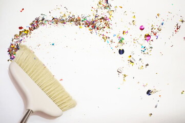 Close-up of broom on the white background.Sweeping confetti after a party or celebration. Colorful...