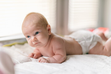 The baby learns to hold its head and lies on its stomach. The benefits of lying on your stomach for motor development