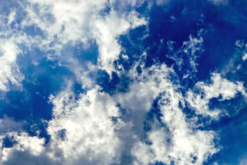 Fluffy white clouds float in the blue sky. Divine view. Wallpaper.