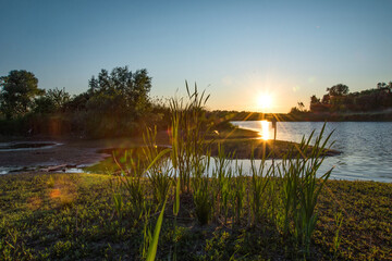 Naklejka premium Sunset with sunbeams on the river