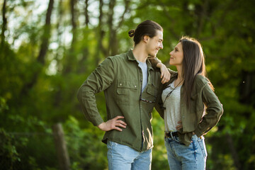 Happy young couple hugging and laughing outdoors in the park