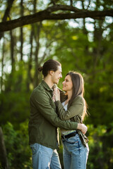 Happy young couple hugging and laughing outdoors in the park