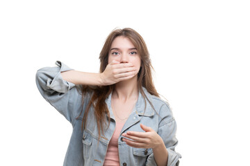 Portrait of a scared teenage girl looking surprised, shocked with a hand covering her mouth, someone gagging her, isolated white background. Human emotions, facial expressions, feelings, body language