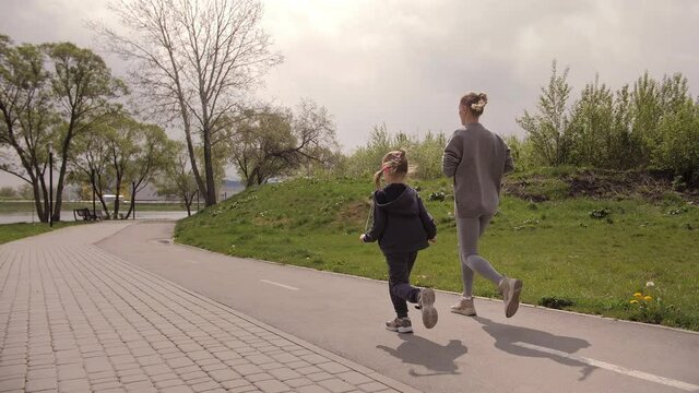 4K Mother and daughter running joggin outdoor in the park