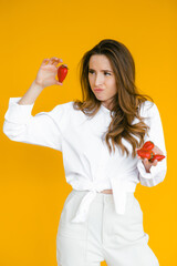 Smiling woman eating strawberry. Close up female face portrait.