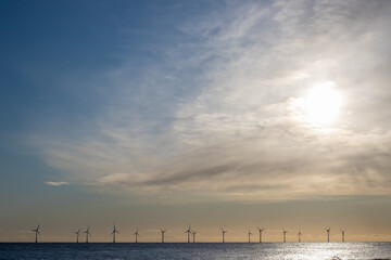 Offshore wind farm turbines on the sea horizon. Background landscape border image